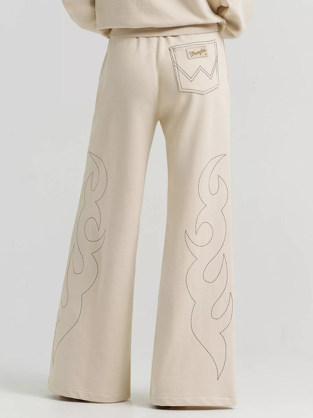 Beige pants with flame patterns on a light gray background