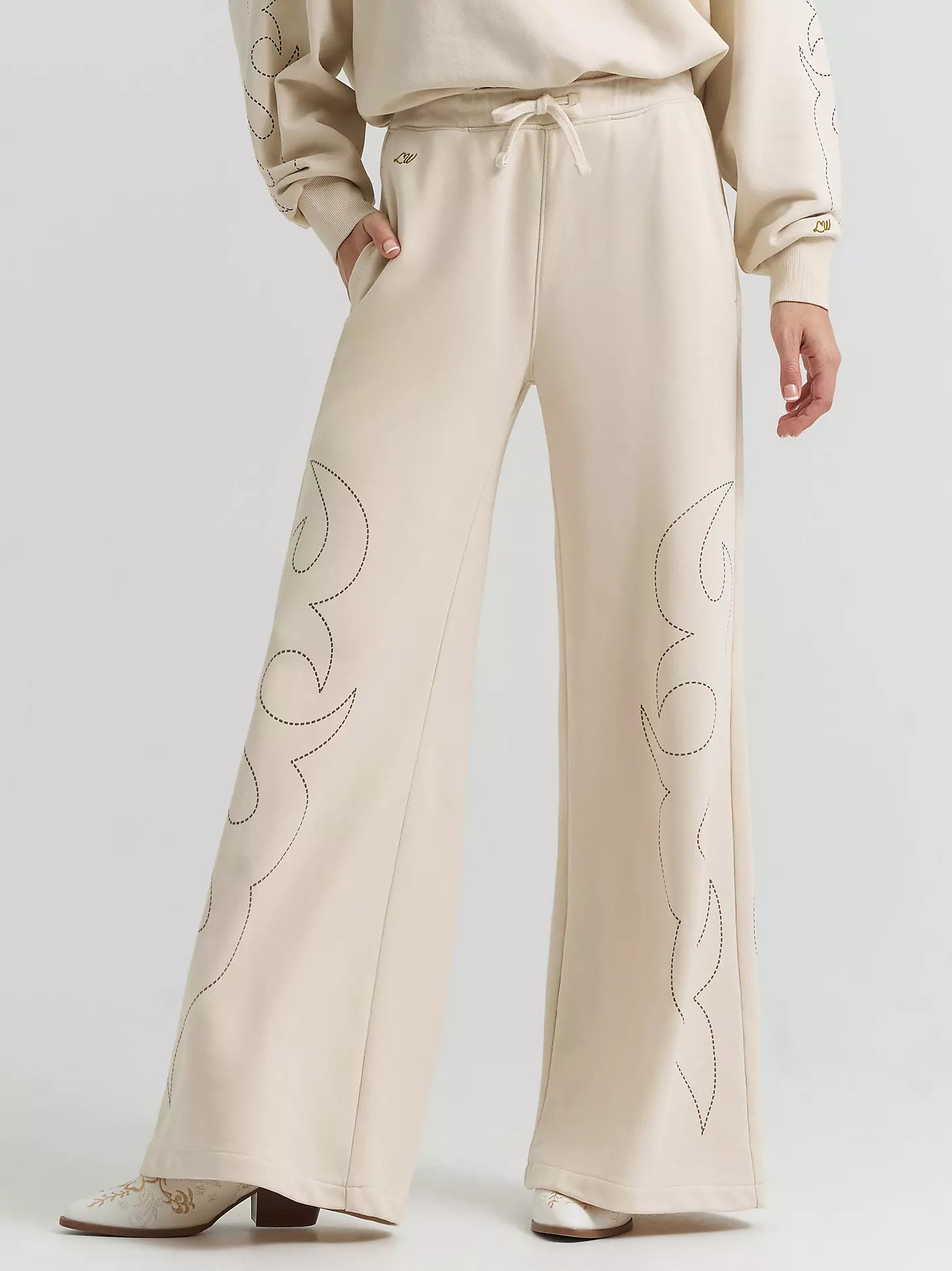 Beige pants with floral embroidery on a white background