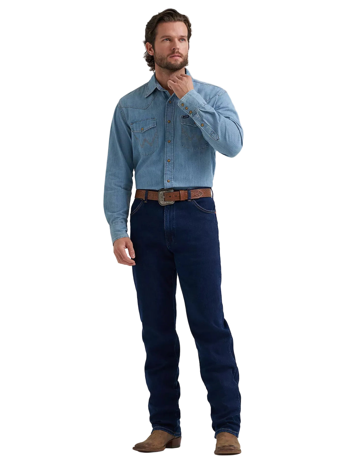 A man modeling a light blue long-sleeve western-style denim shirt with dark blue jeans, a brown leather belt, and brown boots, standing against a light gray studio background.
