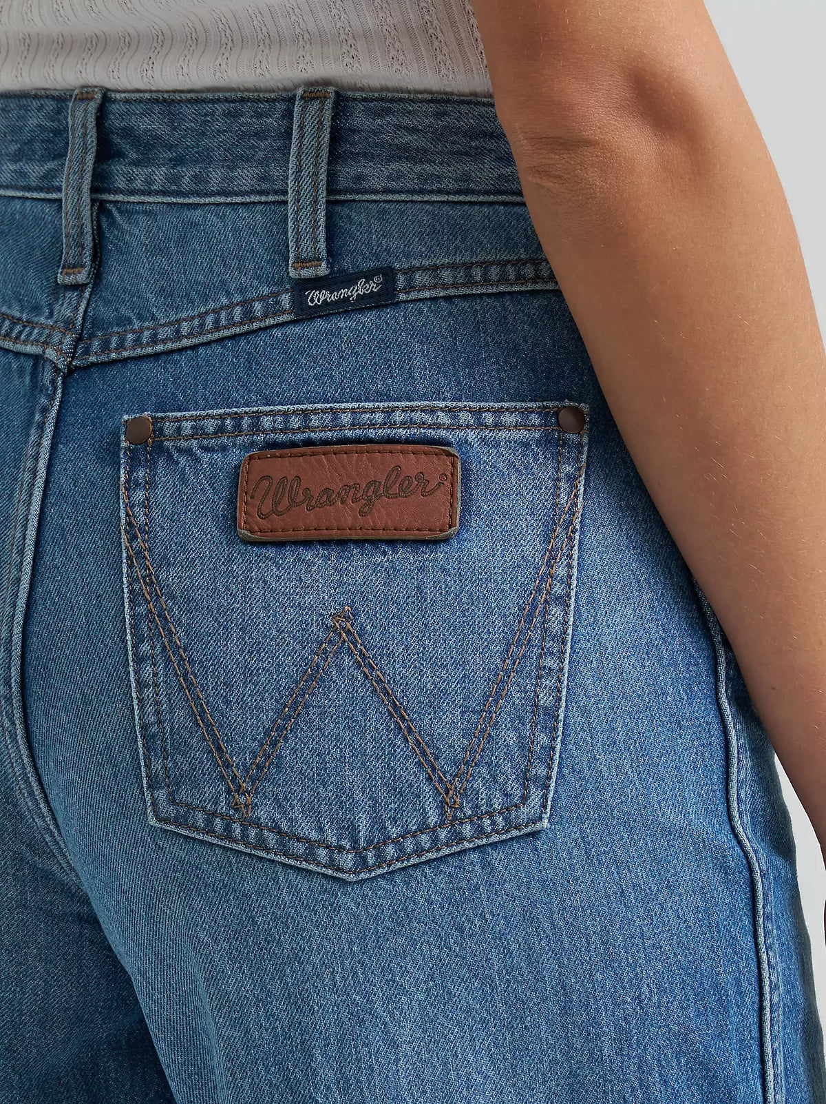 Close-up of blue Wrangler jeans with brand logo on pocket