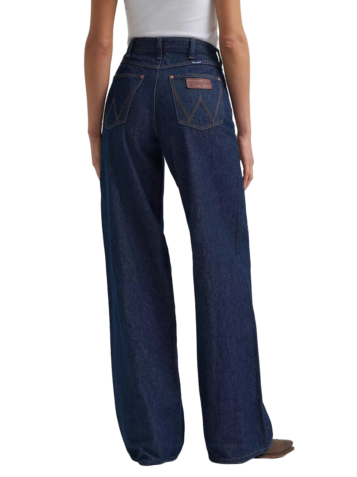 Person wearing dark blue wide-leg jeans on a white background