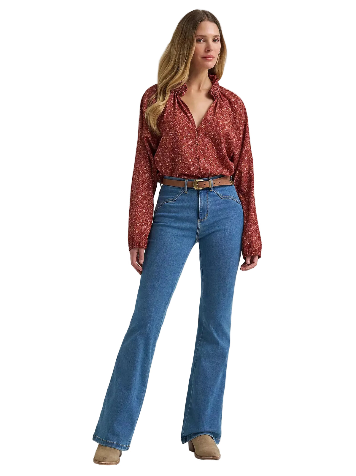 Woman wearing a red patterned blouse and blue jeans on a white background