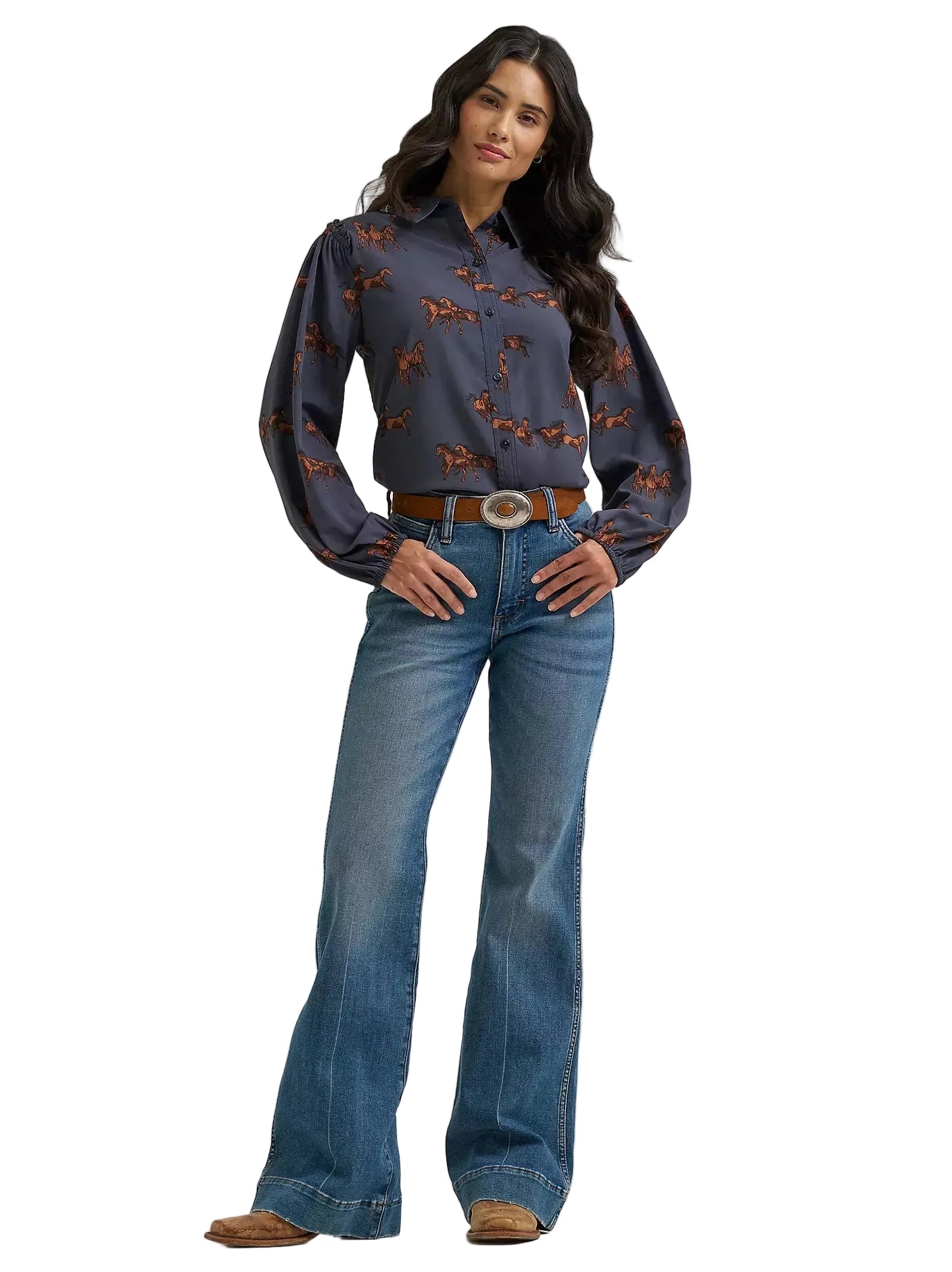 Woman wearing a patterned blouse and blue jeans on a white background