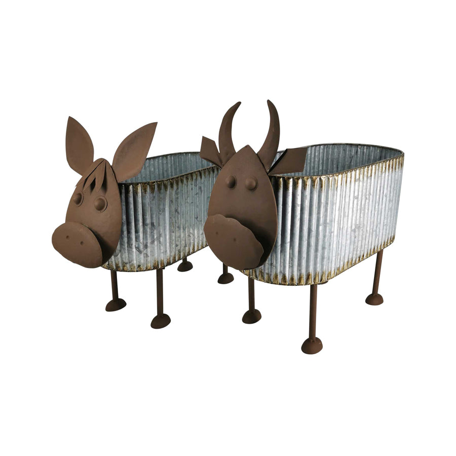 Nested Cow Planters Set of 2. Two decorative planters shaped like cows with flowers on a white background