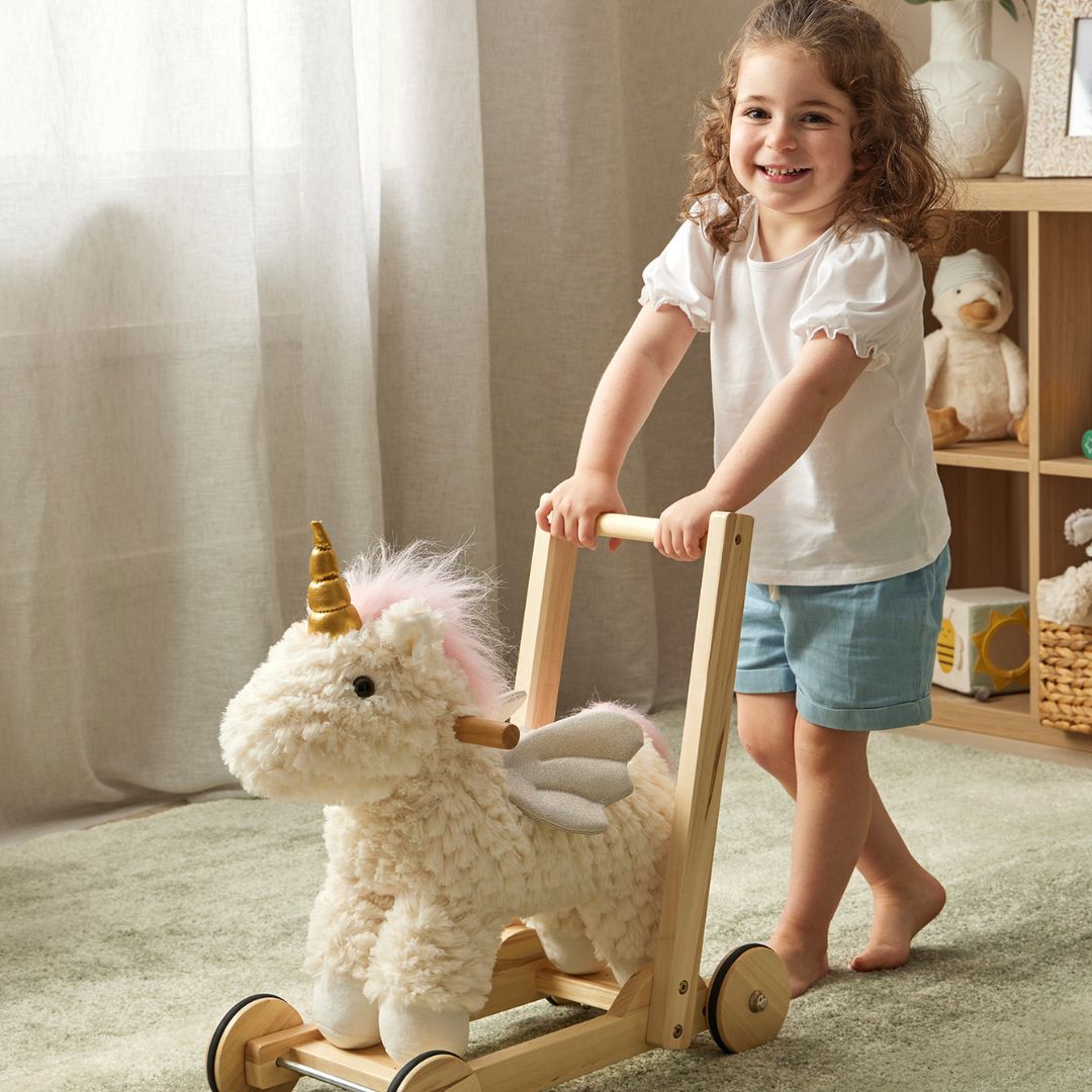 Jiggle & Giggle Unicorn Walker. Child playing with a unicorn-shaped toy in a cozy room.