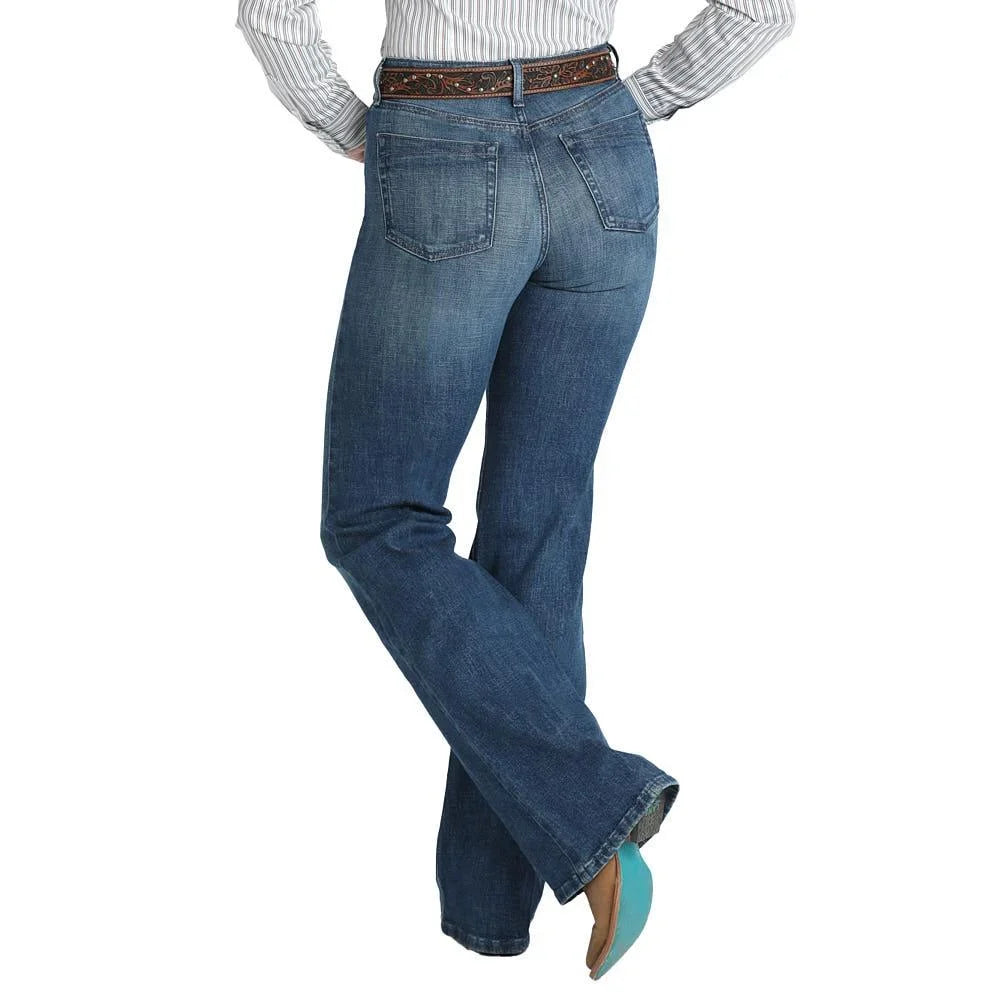 Rear view of a person wearing blue denim jeans with a brown studded belt, a striped shirt, and turquoise cowboy boots against a white background.