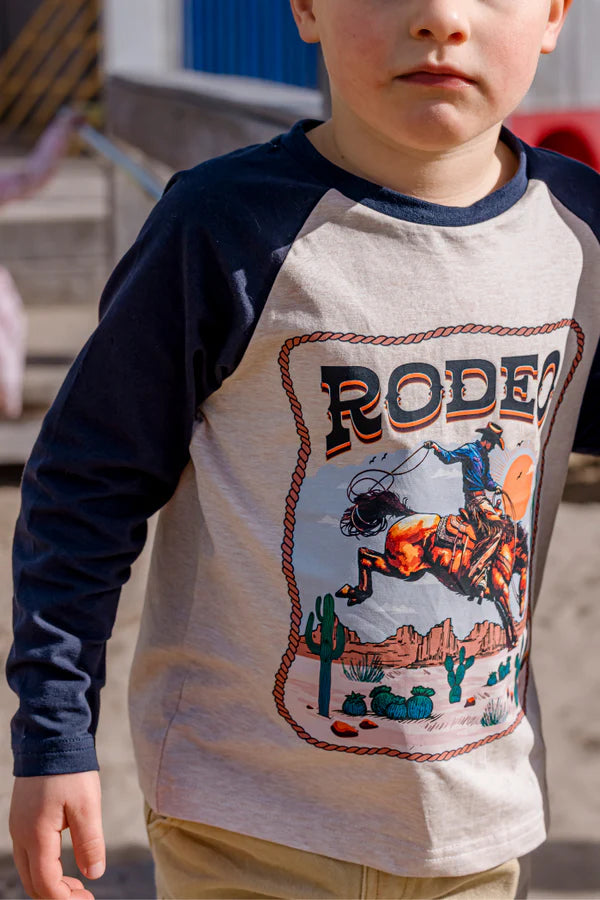 Child wearing a long-sleeve shirt with a rodeo graphic design.