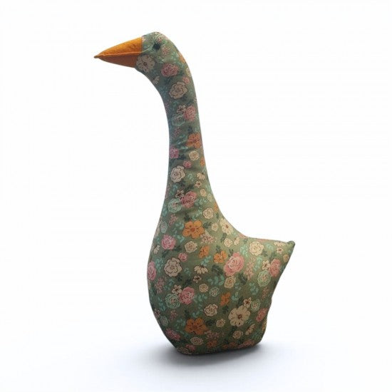 A decorative goose-shaped fabric cushion with a floral pattern on a muted green background and a bright orange beak, shown on a plain white background.