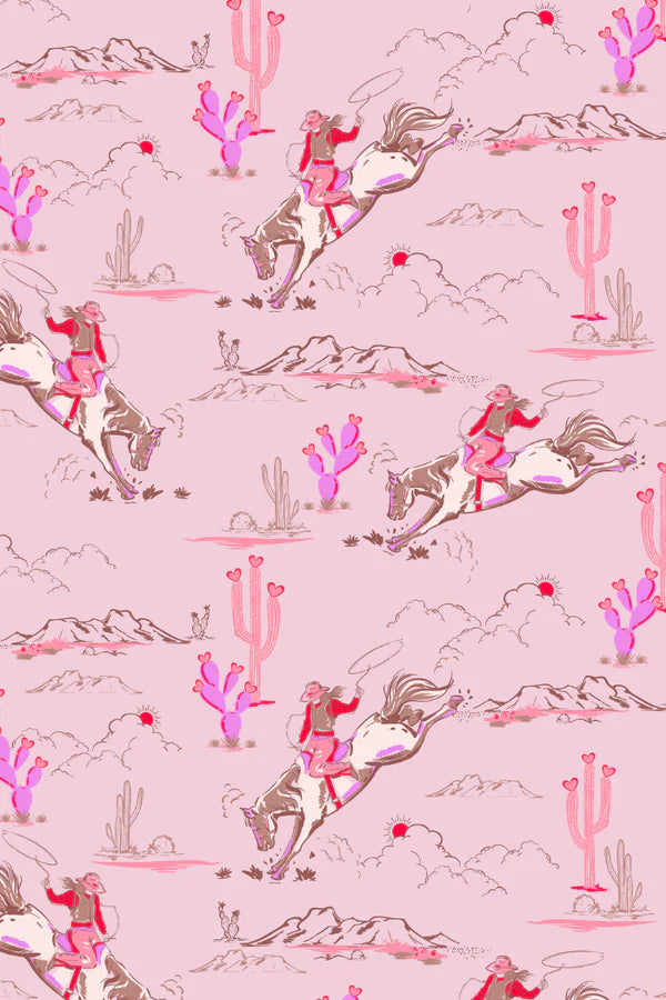 Pattern of cowboys on horses, cacti, and mountains on a pink background
