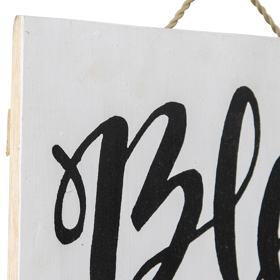 Handcrafted Monochrome Bless Our Nest Wallart. White sign with black cursive text hanging on a white background