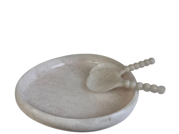 A round white stone tray with a carved spoon resting inside, featuring a textured surface and smooth beaded handles, isolated on a white background.