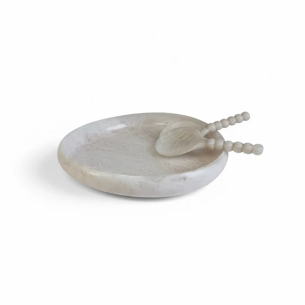 A small oval soap dish and matching spoon set made from pale marbled stone, photographed on a clean white background.