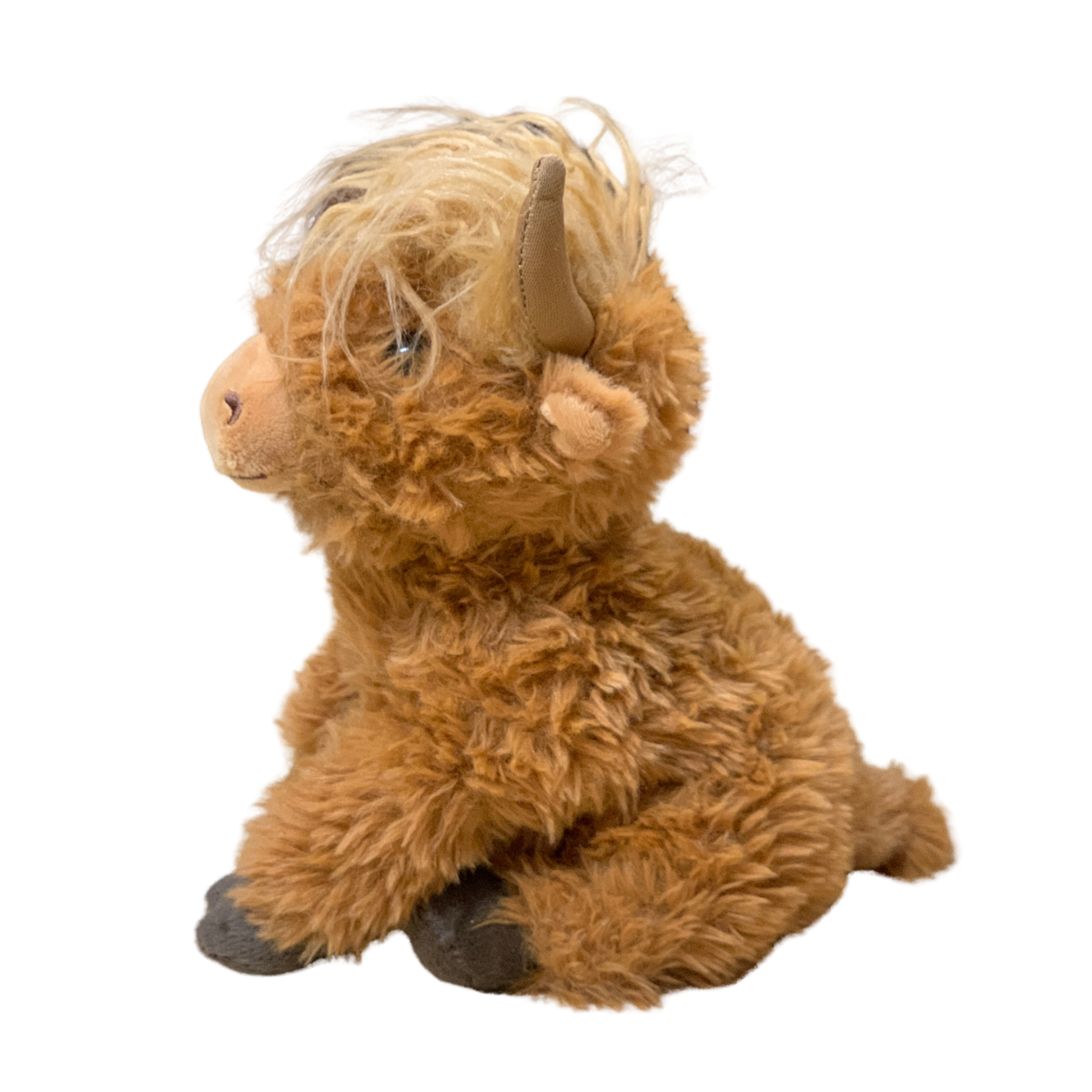 Plush toy of a brown Highland cow on a white background