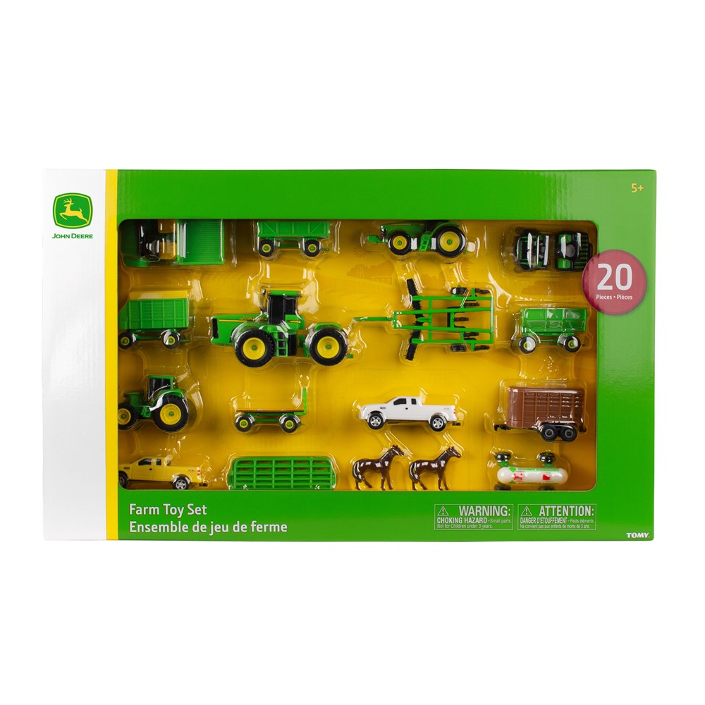 Collection of toy farm vehicles including tractors and trailers on a white background