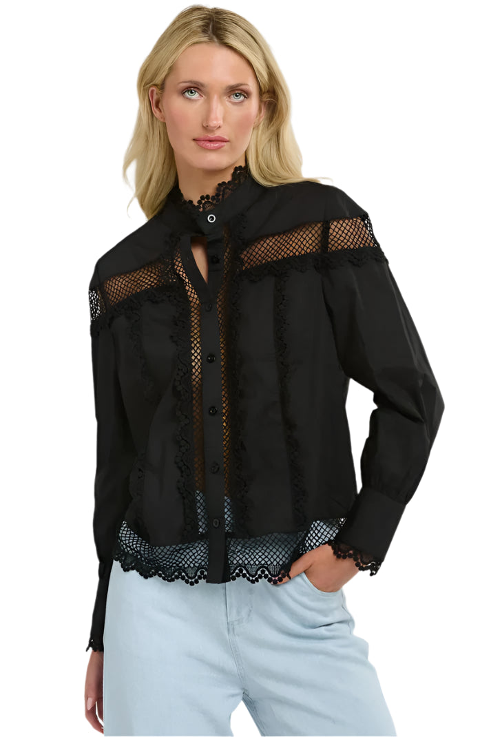 Woman wearing a 365 Women's Victoria Blouse. Black lace-trimmed  with light blue jeans on a white background
