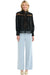 Woman wearing a 365 Women's Victoria Blouse. Black lace-trimmed  with light blue jeans on a white background