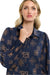 Woman wearing a 365 Women's Mandala Blouse dark blue patterned blouse with a plain background