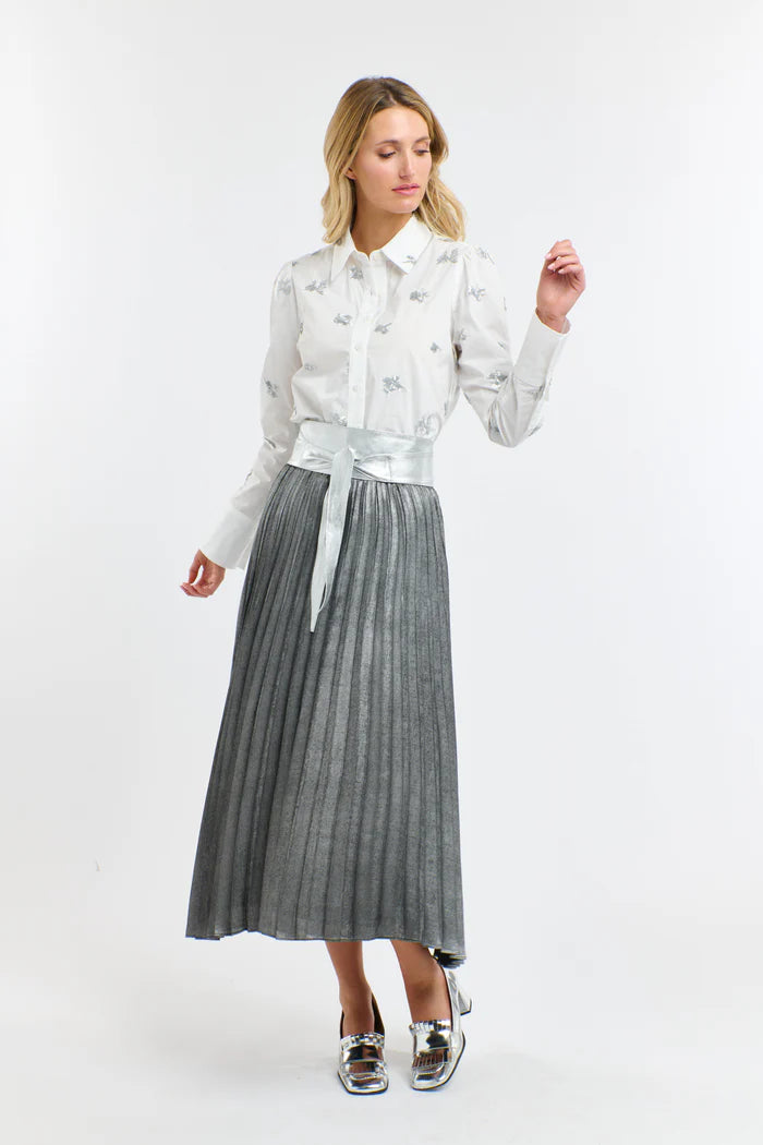 Woman wearing a white blouse and gray pleated skirt on a white background