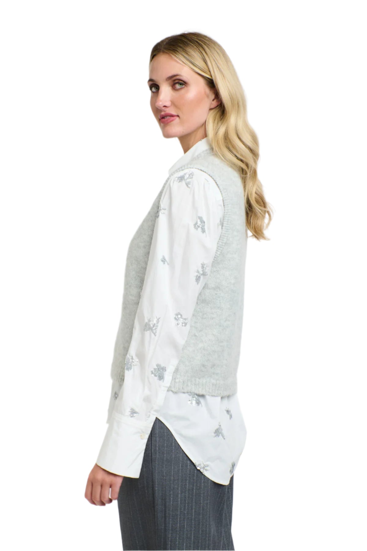 Side view of a woman wearing a 365 Women's Penelope Sequins Shirt. A white shirt with sequin embroidery on a plain background. 