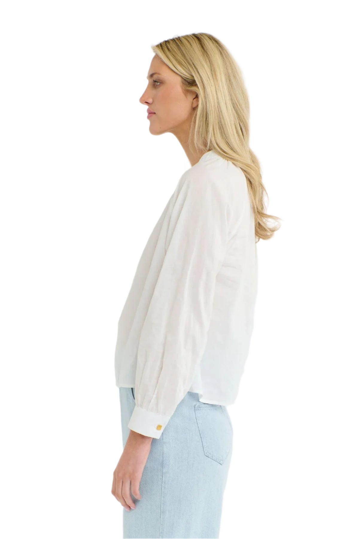 Woman wearing a 365 Women's Layla Cotton Top. A white blouse with gold buttons on a white background