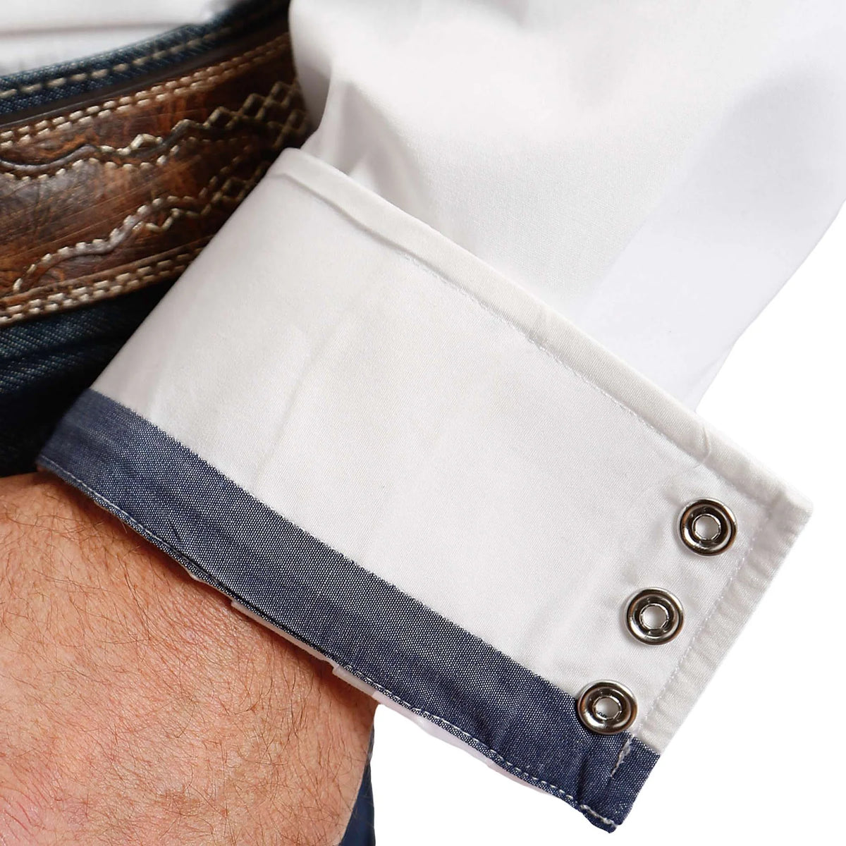 Close-up of a white shirt cuff with blue trim and buttons on a blurred background