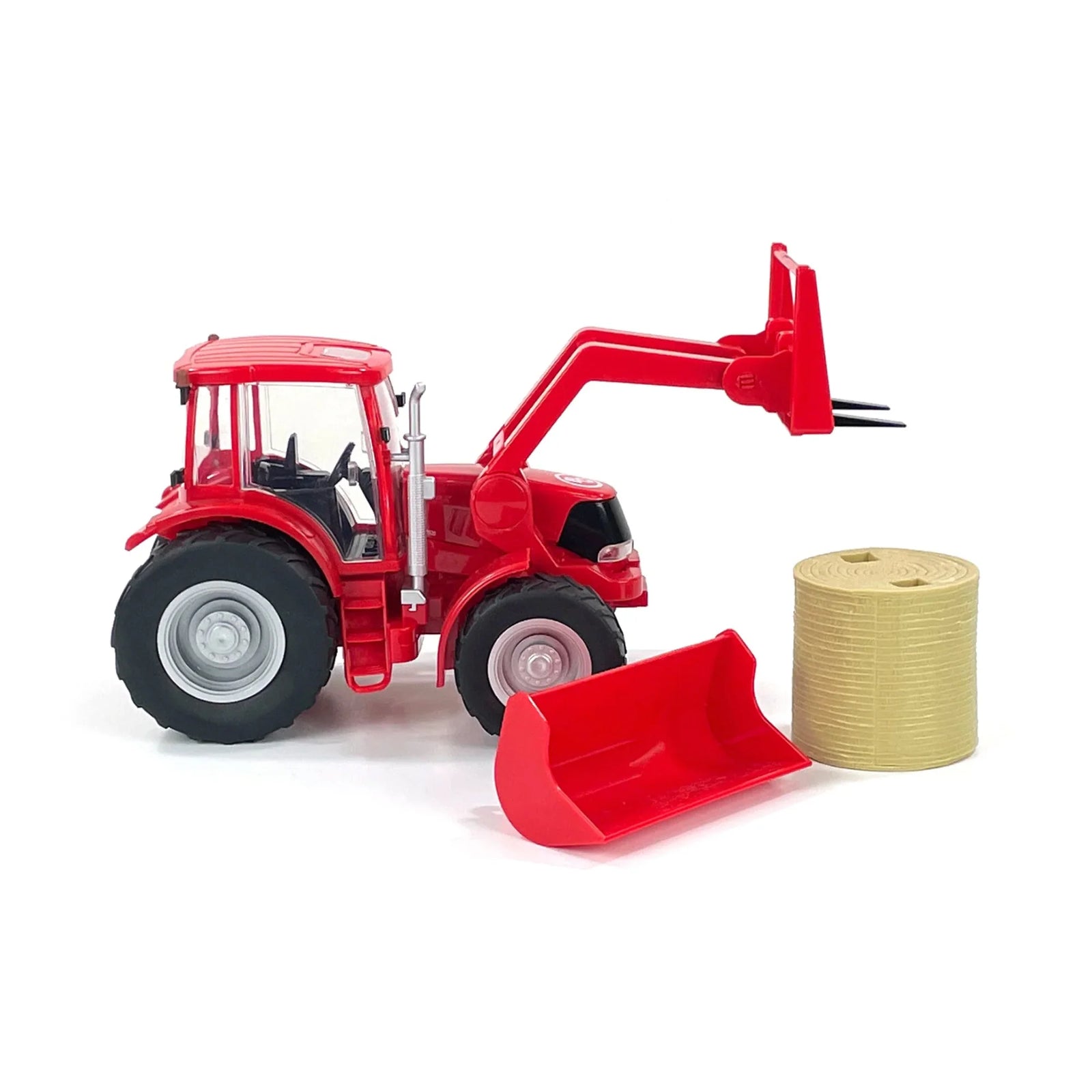 Red toy tractor with front loader and bale of hay on a white background