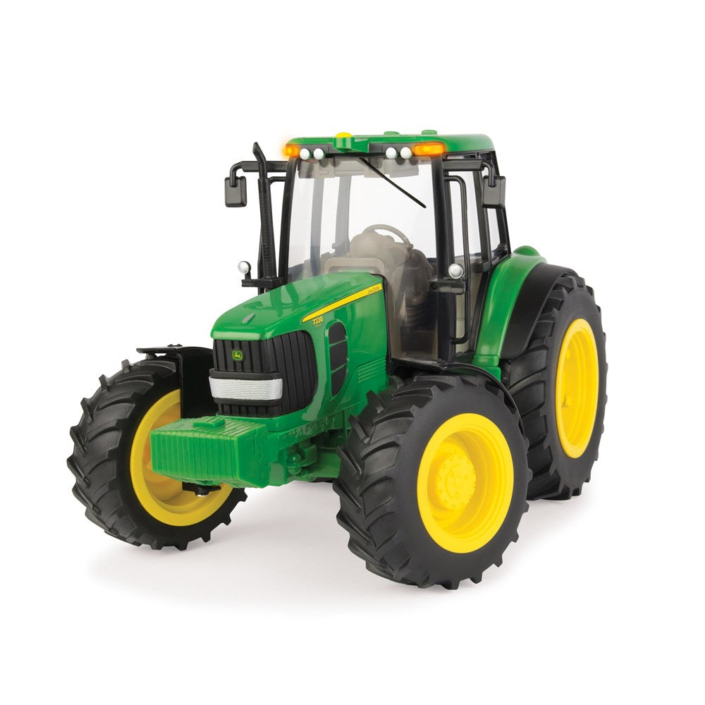Green toy tractor with yellow wheels on a white background