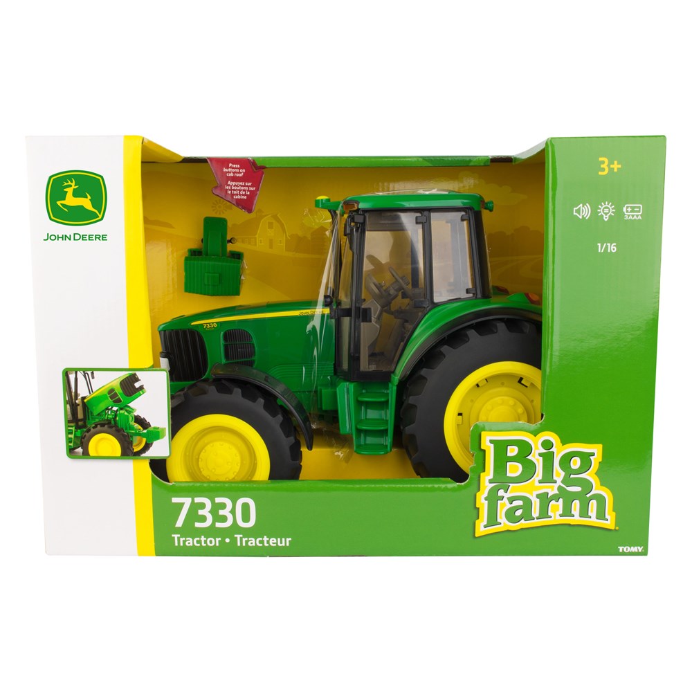John Deere 7330 Tractor toy in its original retail packaging, featuring a green and yellow die-cast model tractor with accessories inside a green and white box.