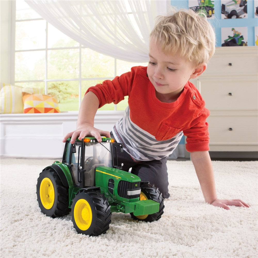 Child playing with a toy tractor indoors