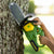 John Deere Motorised Chainsaw. Child's hand holding a John Deere chainsaw against a tree