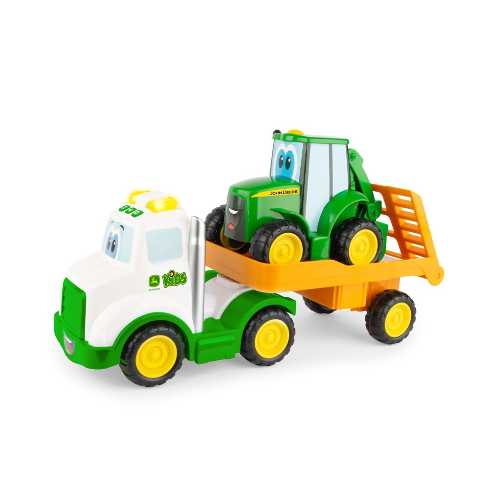 Toy truck carrying a toy tractor on a white background