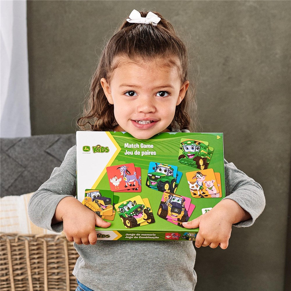 Child holding a John Deere educational game box