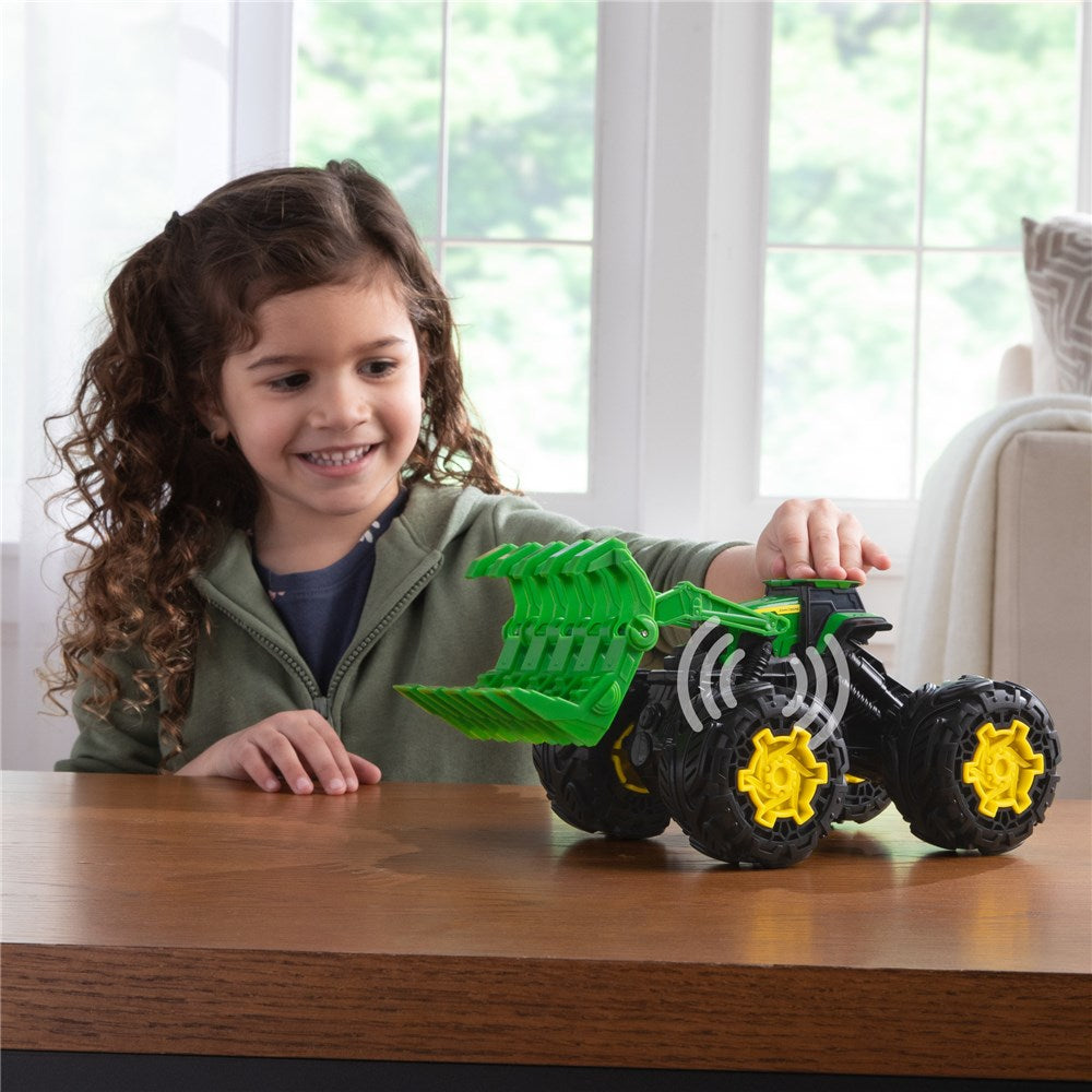Child playing with a toy tractor on a table in a bright room