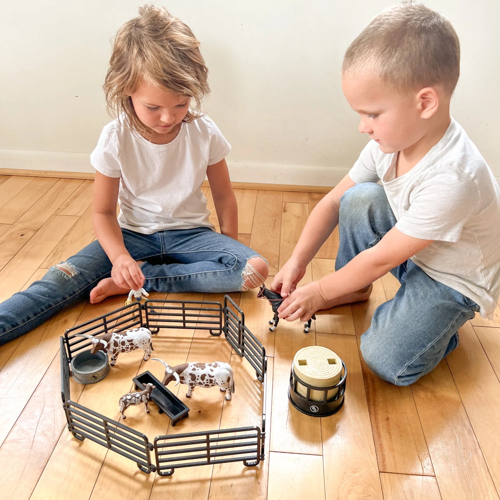 Big Country Toys 12 Piece Small Ranch Set. Model of a livestock pen with crates and cows on a white background