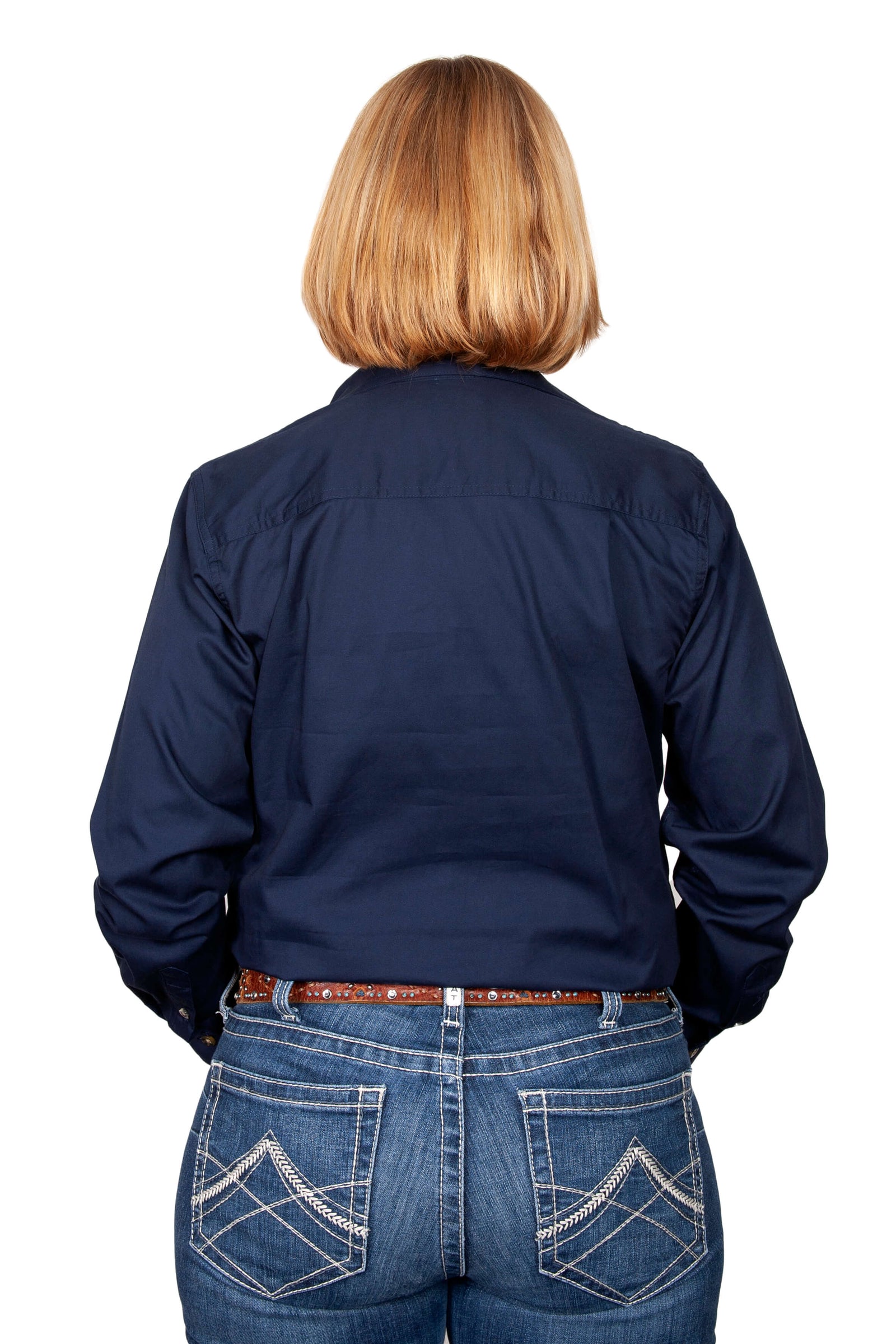 Just Country Women's Brooke Workshirt. A woman wearing a navy blue long-sleeved Just Country workshirt with long tails, double pockets, and a full button front.