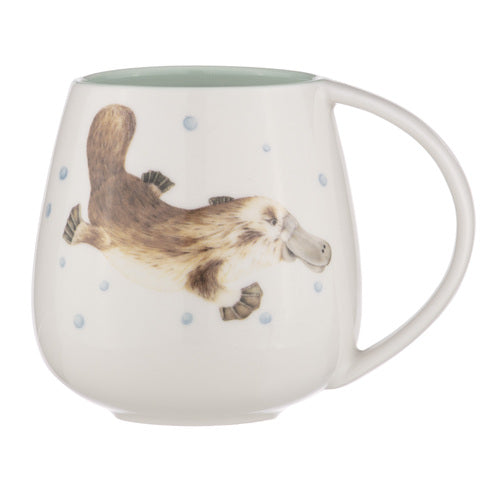 Ashdene Bush Buddies Platlypus Snuggle Mug. A ceramic mug with a handle, featuring a watercolor illustration of a platypus and decorative dots on a white background.
