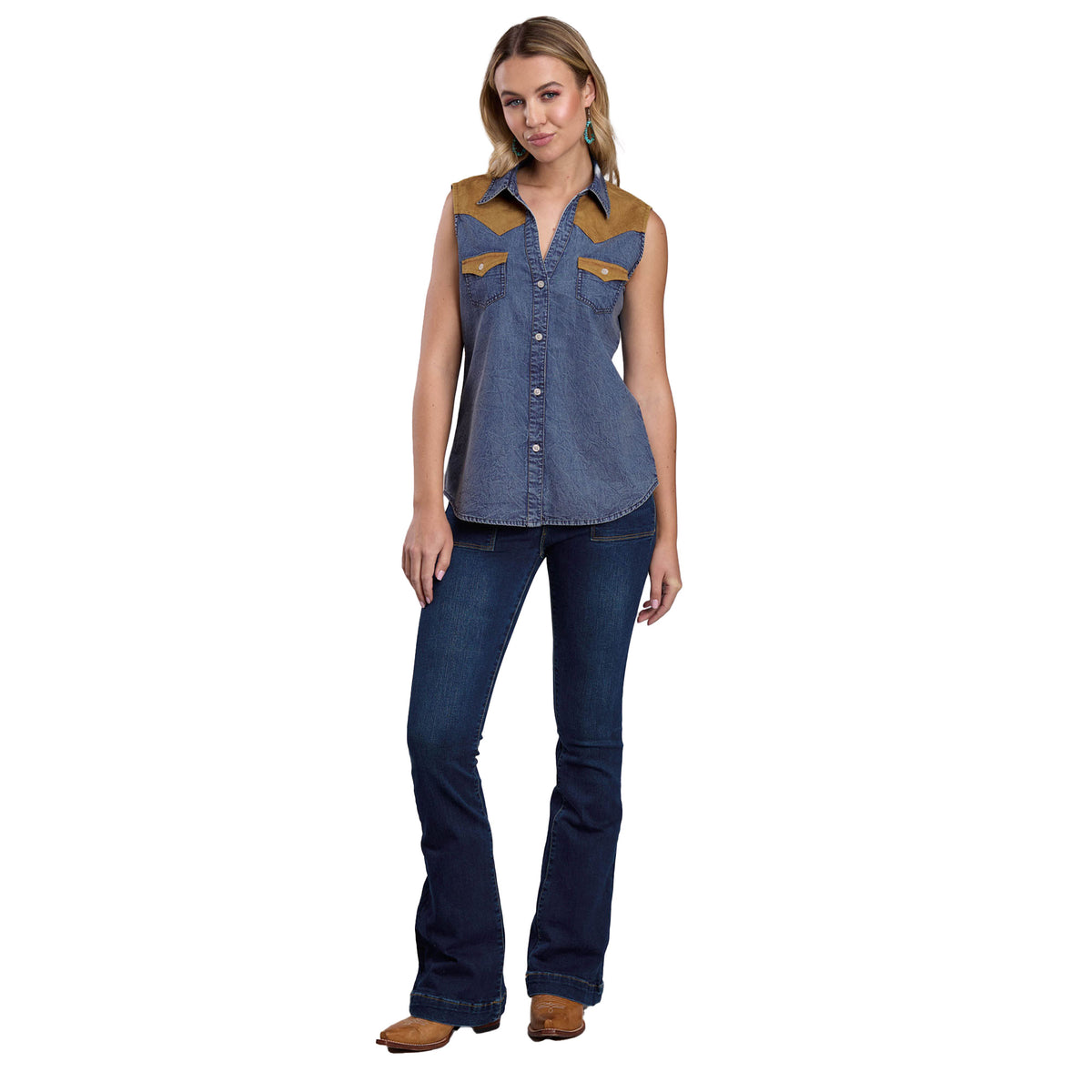 Woman wearing a denim sleeveless shirt with brown accents and dark blue jeans on a white background