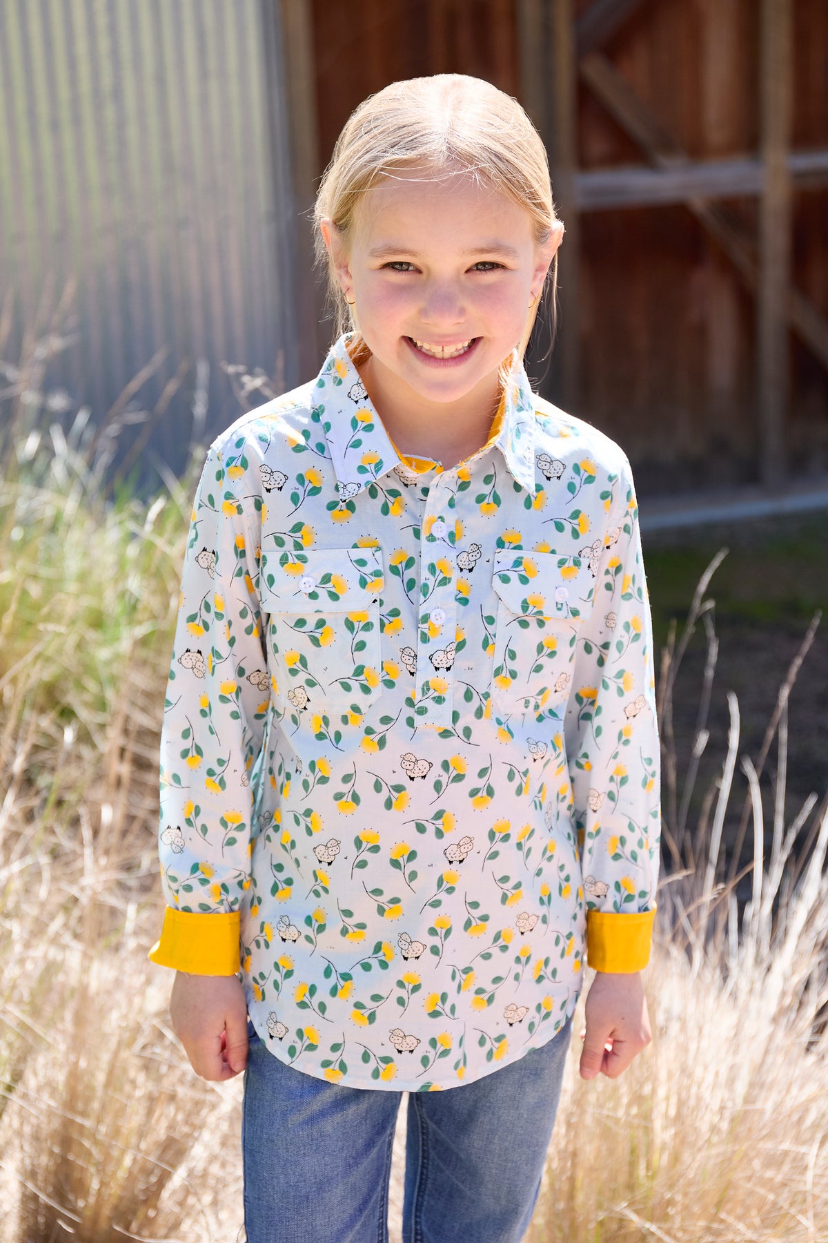 Young girl wearing a floral shirt with yellow accents outdoors
