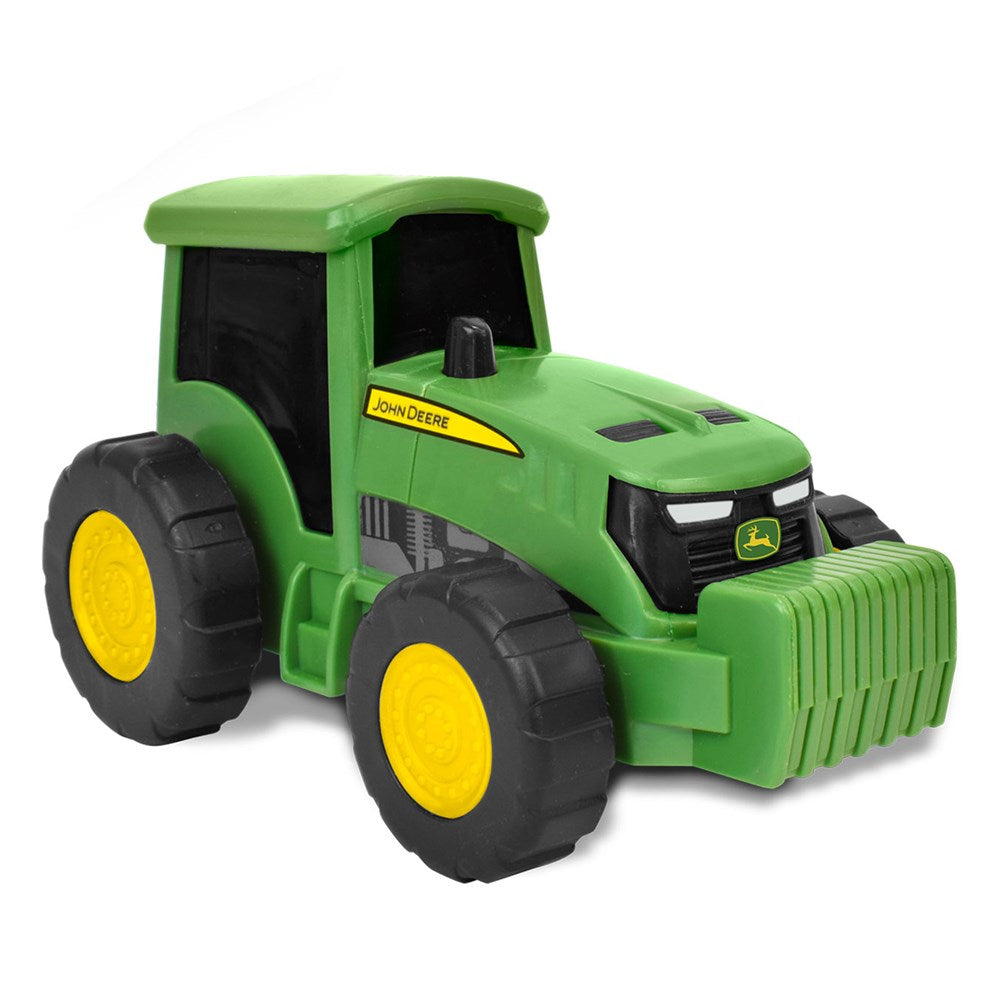 Green toy tractor with black tires and yellow wheels on a white background