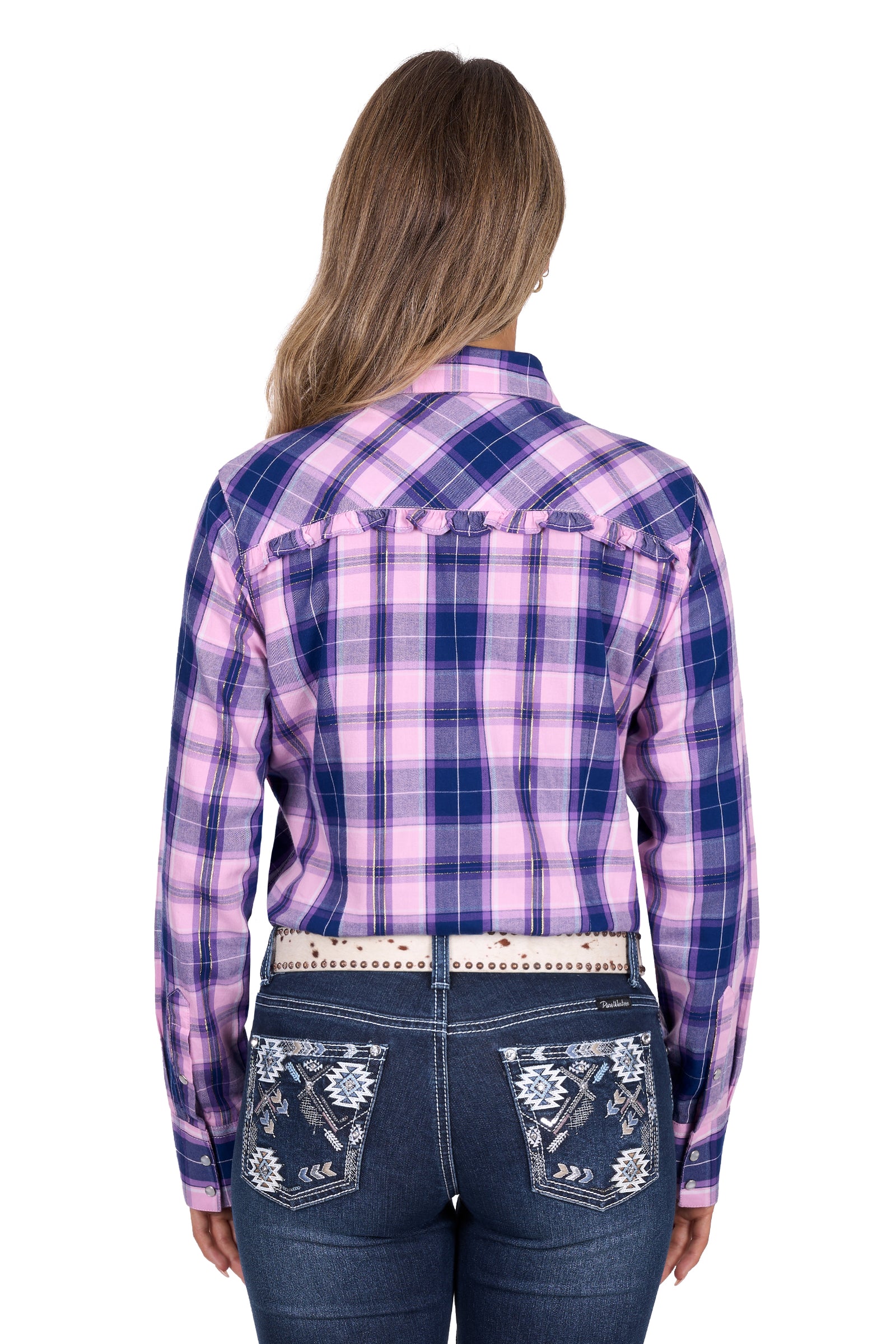 Woman wearing a purple and blue plaid shirt with floral embroidery on jeans.