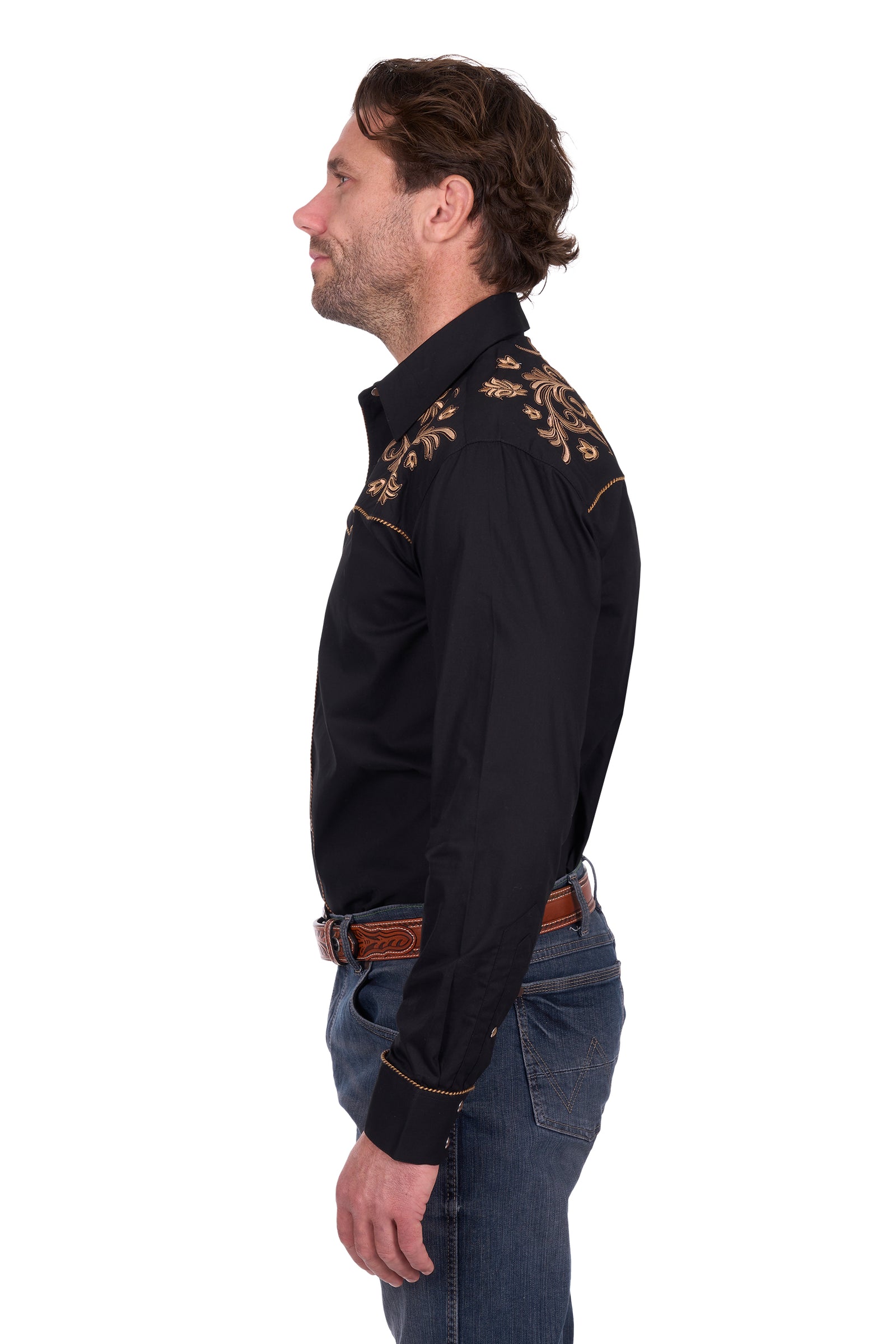 Man wearing a black embroidered shirt with gold details on a white background