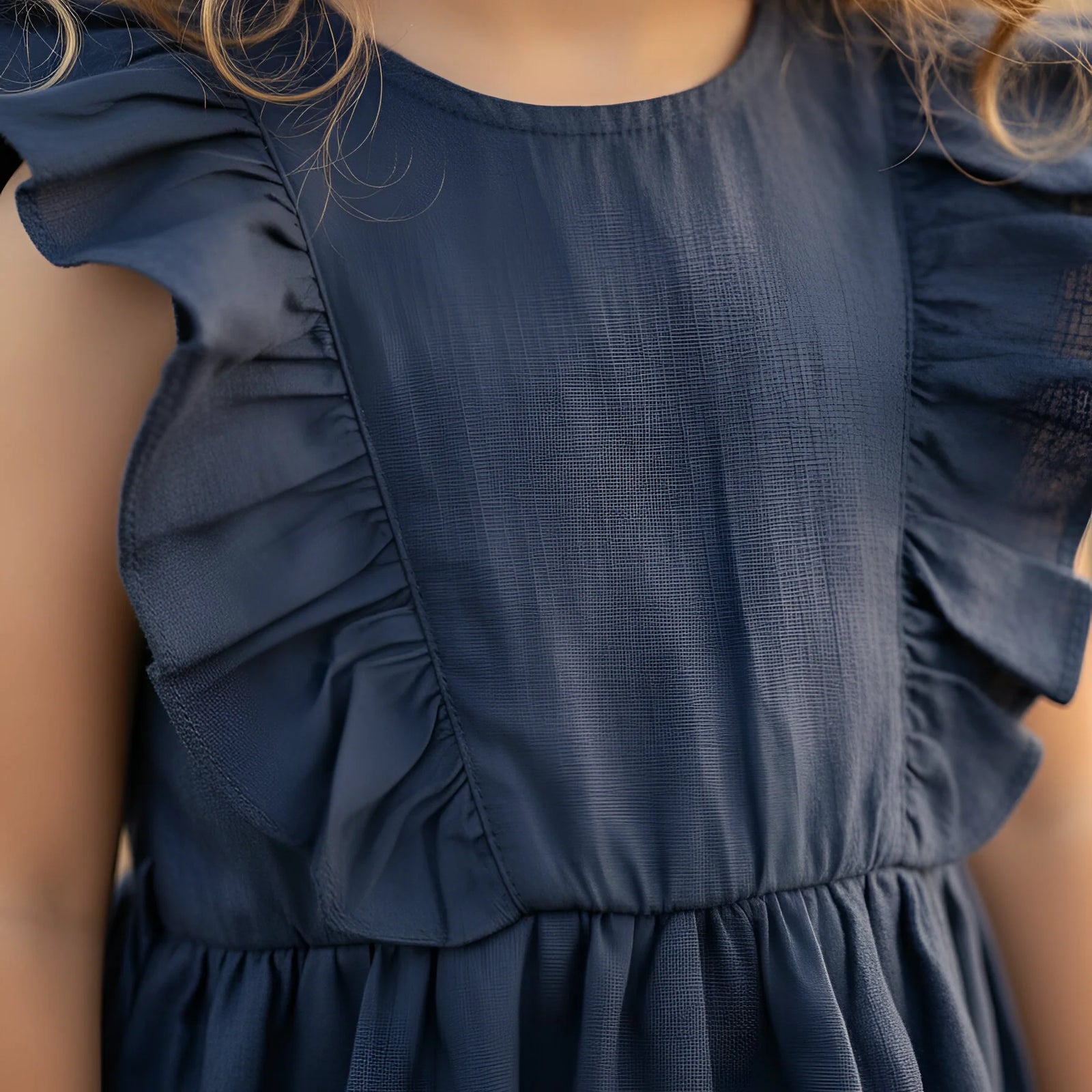 Navy blue dress with ruffled sleeves worn by a child