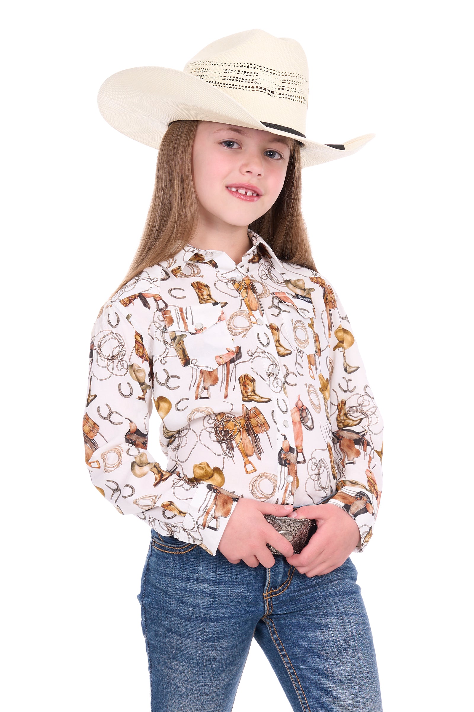 Young girl wearing a cowboy hat and patterned shirt on a white background