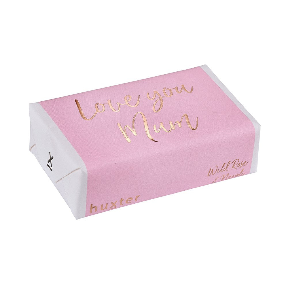 Huxter Love You Mum Soap. A pale pink bar of soap with 'Love you Mum' written in rose gold foil, with the brand name 'Huxter' on the side.