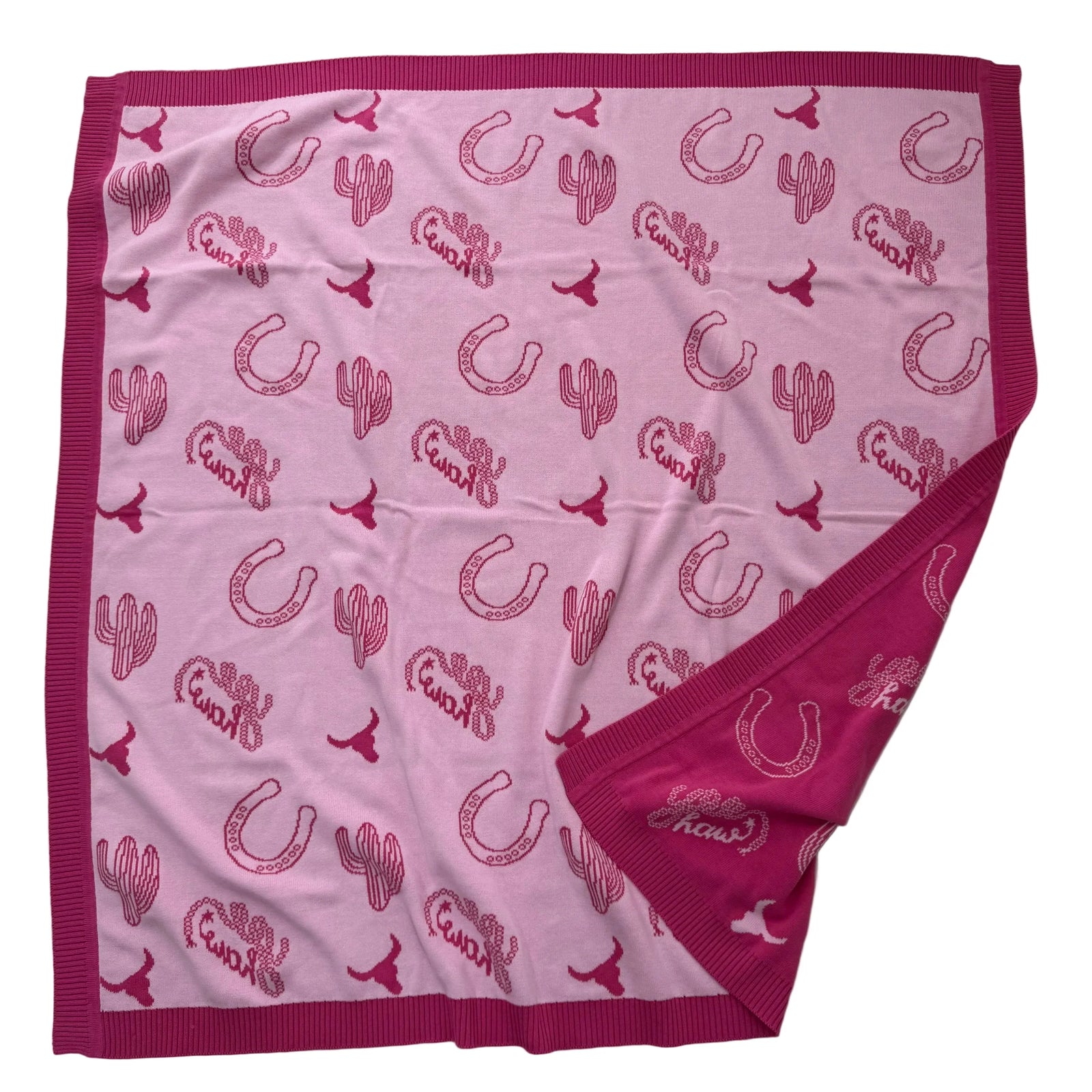 A square pink blanket with a dark magenta border, featuring an all-over print of horseshoes, cacti, and the word 'Cowboy' in matching dark pink script.