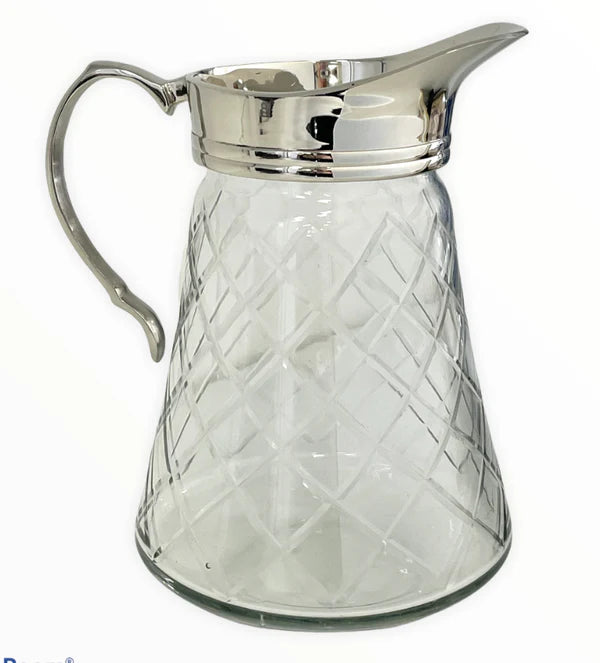 Clear glass pitcher with silver lid and handle on a white background