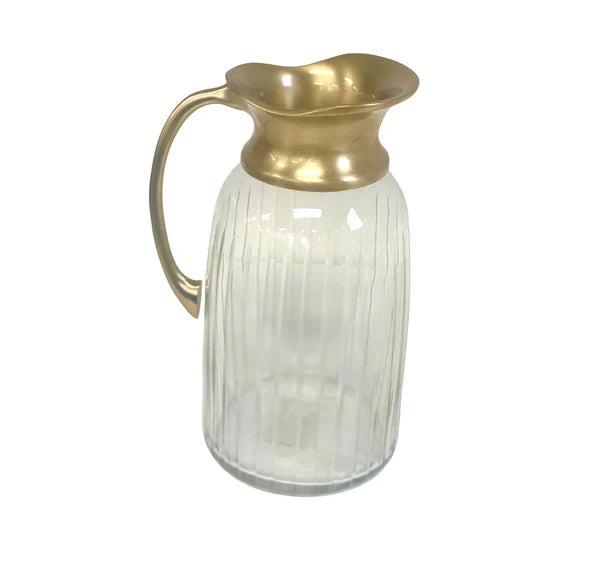 Clear glass pitcher with gold lid on a white background