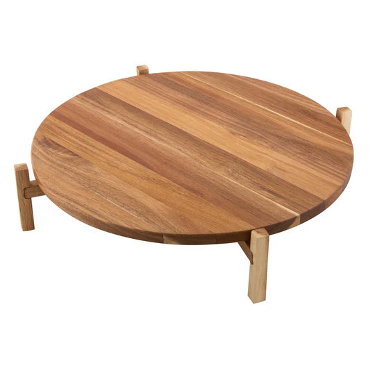 Gather Elevated Lazy Susan. Wooden round cheese board with assorted fruits, meats, and cheeses on a white marble surface.