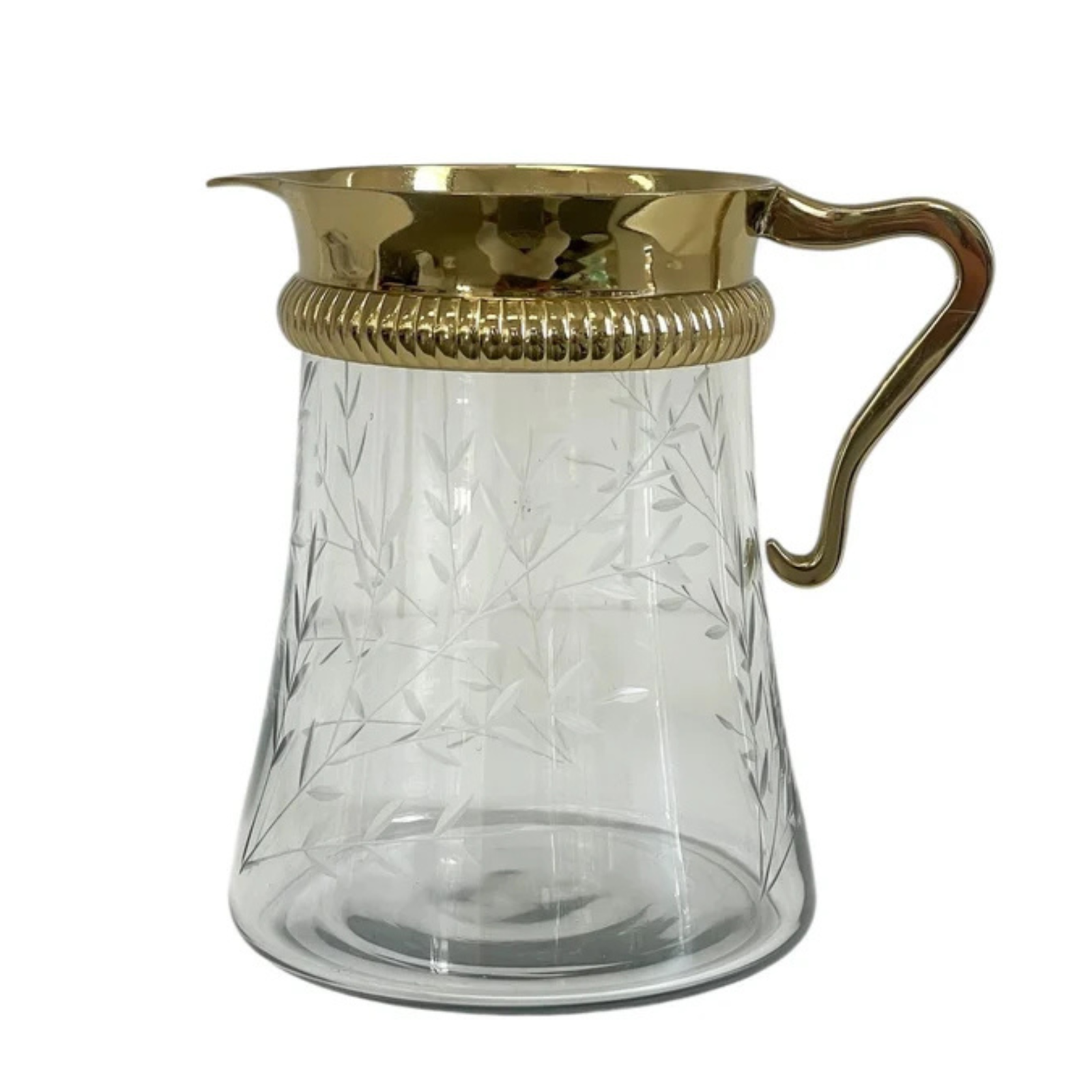 A clear glass pitcher with etched leaf patterns and a polished gold-tone metal handle and rim, shown against a plain white background.