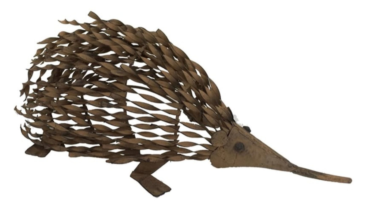 Decorative hedgehog made of brown leaves on a white background